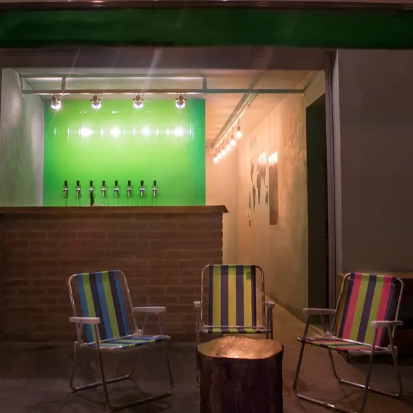 A primeira casa em Juquehy: cadeiras de praia na frente do balcão com as 8 torneiras na parede verde